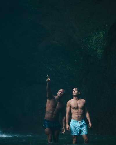 两个男人站在洞穴内的水域

